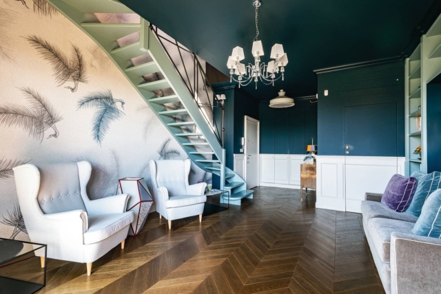 Ingresso casa ristrutturata in stile classico moderno, due bergere bianche sotto la scala in legno dipinta di verde, divano grigio. Alle pareti carta da parati con motivo a foglie, boiserie bianca alternata a pittura di colore blu. Ingresso casa ristrutturata in stile classico moderno, due bergere bianche sotto la scala in legno dipinta di verde, divano grigio. Alle pareti carta da parati con motivo a foglie, boiserie bianca alternata a pittura di colore blu.