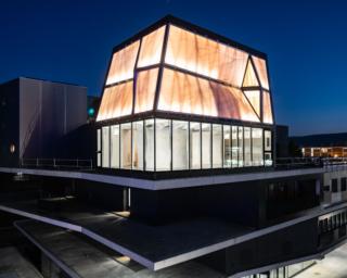 DFAB HOUSE e l'edificio NEST illuminato contro il cielo notturno. Foto: Roman Keller DFAB HOUSE e l'edificio NEST illuminato contro il cielo notturno. Foto: Roman Keller