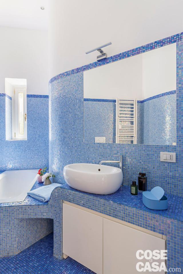 bagno del trilocale rinnovato, rivestimenti a mosaico azzurro, specchio incassato, vasca, mobile lavabo in muratura, scomparti, lavabo da appoggio in ceramica bagno del trilocale rinnovato, rivestimenti a mosaico azzurro, specchio incassato, vasca, mobile lavabo in muratura, scomparti, lavabo da appoggio in ceramica