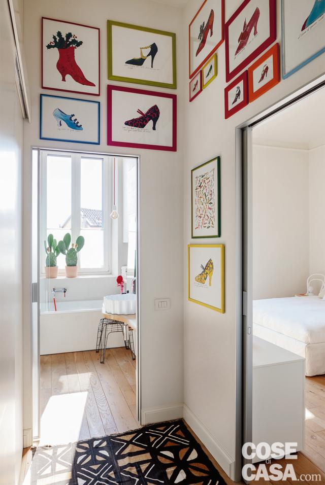 disimpegno del bilocale recuperato, ingresso della camera e del bagno, stampe incorniciate a parete con cornici colorate, pavimento in parquet disimpegno del bilocale recuperato, ingresso della camera e del bagno, stampe incorniciate a parete con cornici colorate, pavimento in parquet