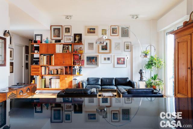soggiorno, zona conversazione, libreria vintage, divano in pelle nera, lampada ad arco, quadri, plafoniere, radiatore d'arredo, busto, portafinestra soggiorno, zona conversazione, libreria vintage, divano in pelle nera, lampada ad arco, quadri, plafoniere, radiatore d'arredo, busto, portafinestra