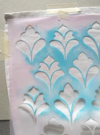 4. Fissate lo stencil sulla stoffa con il nastro carta e mettete un cartone sotto la stoffa per non macchiare il piano 4. Fissate lo stencil sulla stoffa con il nastro carta e mettete un cartone sotto la stoffa per non macchiare il piano
