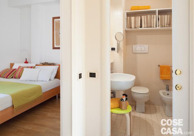 Disimpegno del trilocale ristrutturato, camera matrimoniale, bagno, porta scorrevole, lavabo, sanitari, mobile pensile in laccato bianco Disimpegno del trilocale ristrutturato, camera matrimoniale, bagno, porta scorrevole, lavabo, sanitari, mobile pensile in laccato bianco