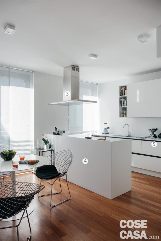 In cucina, la composizione su due lati e la penisola in laccato bianco con maniglie a gola evidenziate dalla finitura scura sono su disegno del progettista; i piani di lavoro sono in Superwhite13 di Stone Italiana, certificati NSF per la sicurezza nel contatto con gli alimenti. Il lavello a una vasca e mezza è in acciao inox con incasso filotop. La cappa a isola in acciaio è di Falmec.
3. La cappa al centro
In acciaio satinato, è un modello aspirante a isola, installato sopra la penisola, in corrispondenza del piano cottura a gas (a distanza di 80 cm circa). Per consentire il passaggio del condotto di evacuazione fumi, è stata realizzata una controsoffittatura in cartongesso, utile anche per installare i faretti.
4. Funzioni mimetizzate
Il blocco centrale a penisola, che come gli altri mobili della cucina è su disegno, è pensato in modo tale che – guardando dalla zona pranzo o dall’area living – il piano cottura e il piano di lavoro non risultano mai visibili perché sono nascosti da un’alzata di circa 25 cm che prolunga in altezza lo schienale del mobile.
5. In quarzo ricomposto
Sono in questo materiale i piani di lavoro, con finitura bianca come i frontali dei mobili. Rispetto ai solid surface, i quarzi ricomposti hanno formule che prevedono una percentuale inferiore di resina (solo del 7-8% circa). Le superifici – in questo caso di spessore 1,3 cm – sono molto resistenti, antigraffio e antimacchia. In cucina, la composizione su due lati e la penisola in laccato bianco con maniglie a gola evidenziate dalla finitura scura sono su disegno del progettista; i piani di lavoro sono in Superwhite13 di Stone Italiana, certificati NSF per la sicurezza nel contatto con gli alimenti. Il lavello a una vasca e mezza è in acciao inox con incasso filotop. La cappa a isola in acciaio è di Falmec.
3. La cappa al centro
In acciaio satinato, è un modello aspirante a isola, installato sopra la penisola, in corrispondenza del piano cottura a gas (a distanza di 80 cm circa). Per consentire il passaggio del condotto di evacuazione fumi, è stata realizzata una controsoffittatura in cartongesso, utile anche per installare i faretti.
4. Funzioni mimetizzate
Il blocco centrale a penisola, che come gli altri mobili della cucina è su disegno, è pensato in modo tale che – guardando dalla zona pranzo o dall’area living – il piano cottura e il piano di lavoro non risultano mai visibili perché sono nascosti da un’alzata di circa 25 cm che prolunga in altezza lo schienale del mobile.
5. In quarzo ricomposto
Sono in questo materiale i piani di lavoro, con finitura bianca come i frontali dei mobili. Rispetto ai solid surface, i quarzi ricomposti hanno formule che prevedono una percentuale inferiore di resina (solo del 7-8% circa). Le superifici – in questo caso di spessore 1,3 cm – sono molto resistenti, antigraffio e antimacchia.