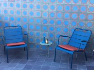 Terrazzo ristrutturato; piastrelle in gres a pavimento e cementine decorate a parete; sedie Fermob in ferro Terrazzo ristrutturato; piastrelle in gres a pavimento e cementine decorate a parete; sedie Fermob in ferro