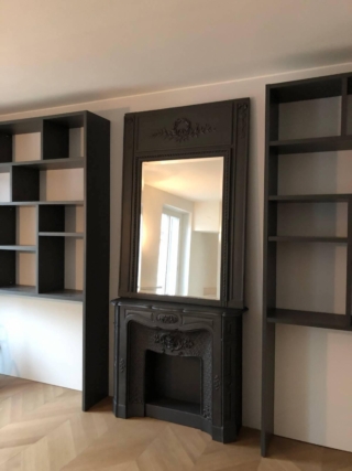 parete soggiorno librerie laccate nere, camino e specchio