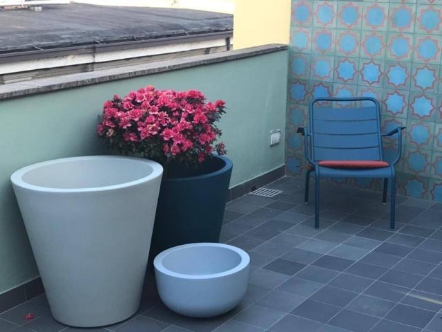 terrazzino ristrutturato di una casa di ringhiera, con gres a pavimento e e cemetine decorative a parete; vasi di Serralunga e sedie di Fermob terrazzino ristrutturato di una casa di ringhiera, con gres a pavimento e e cemetine decorative a parete; vasi di Serralunga e sedie di Fermob