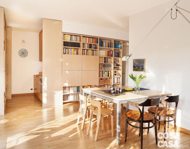 zona pranzo del trilocale ristrutturato, tavolo, sedie in legno, lampada orientabile, mobile libreria riadattato, angolo cottura, pavimento in parquet zona pranzo del trilocale ristrutturato, tavolo, sedie in legno, lampada orientabile, mobile libreria riadattato, angolo cottura, pavimento in parquet