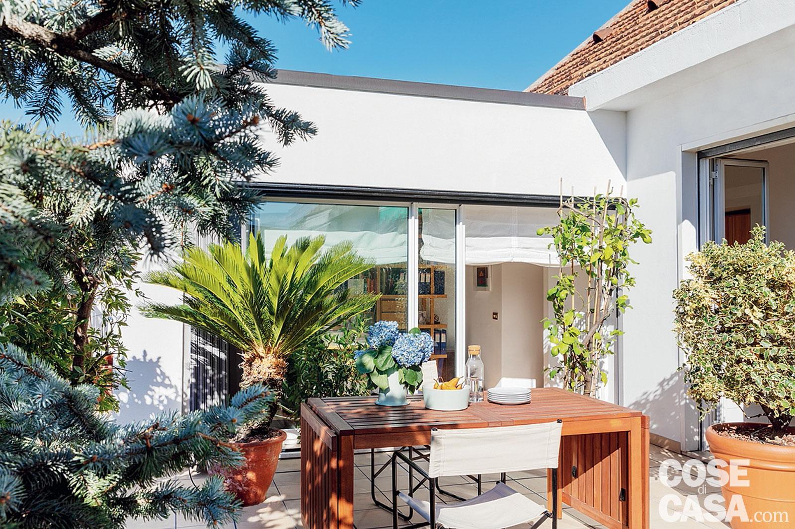 terrazzo, vetrate, tavolo in legno, sedie in tela, piante in vaso terrazzo, vetrate, tavolo in legno, sedie in tela, piante in vaso