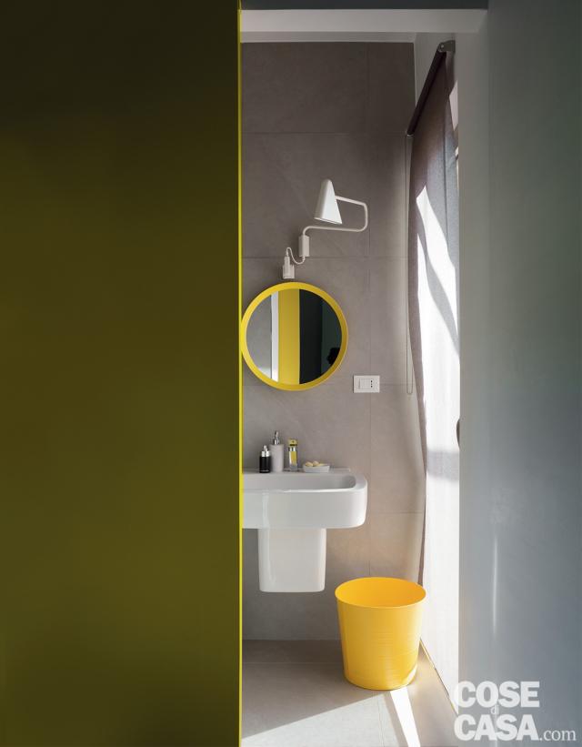 bagno, lavabo sospeso, cestino giallo, specchio con cornice gialla, applique, parete grigia effetto cemento, portafinestra bagno, lavabo sospeso, cestino giallo, specchio con cornice gialla, applique, parete grigia effetto cemento, portafinestra
