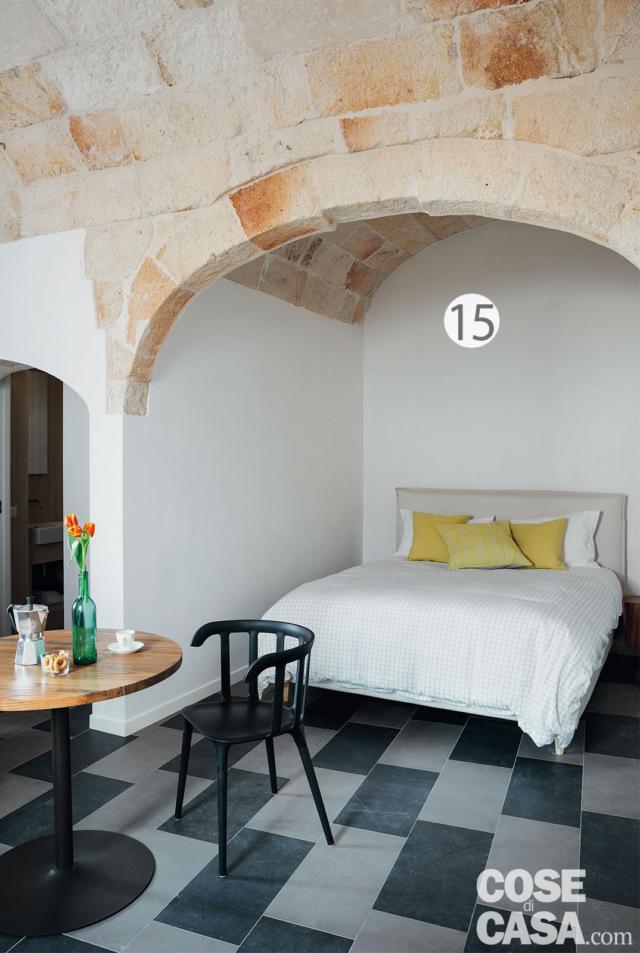 camera matrimoniale, letto sotto la volta, tavolo rotondo, sedia nera, pavimento a scacchi camera matrimoniale, letto sotto la volta, tavolo rotondo, sedia nera, pavimento a scacchi