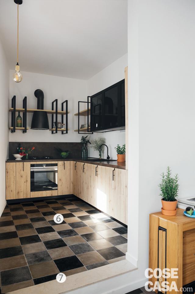 cucina, pavimento in cementine, gradino, composizione su due lati, mobili con frontali in legno grezzo, top e pensili neri, cappa rétro, lampada a sospensione con cavo a vista cucina, pavimento in cementine, gradino, composizione su due lati, mobili con frontali in legno grezzo, top e pensili neri, cappa rétro, lampada a sospensione con cavo a vista
