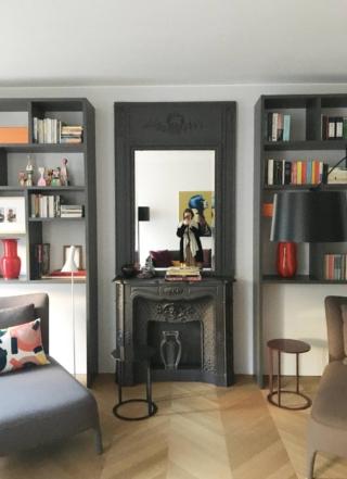 Parete soggiorno arredata con librerie, specchio e finto camino in ghisa dipinti grigio antracite Parete soggiorno arredata con librerie, specchio e finto camino in ghisa dipinti grigio antracite