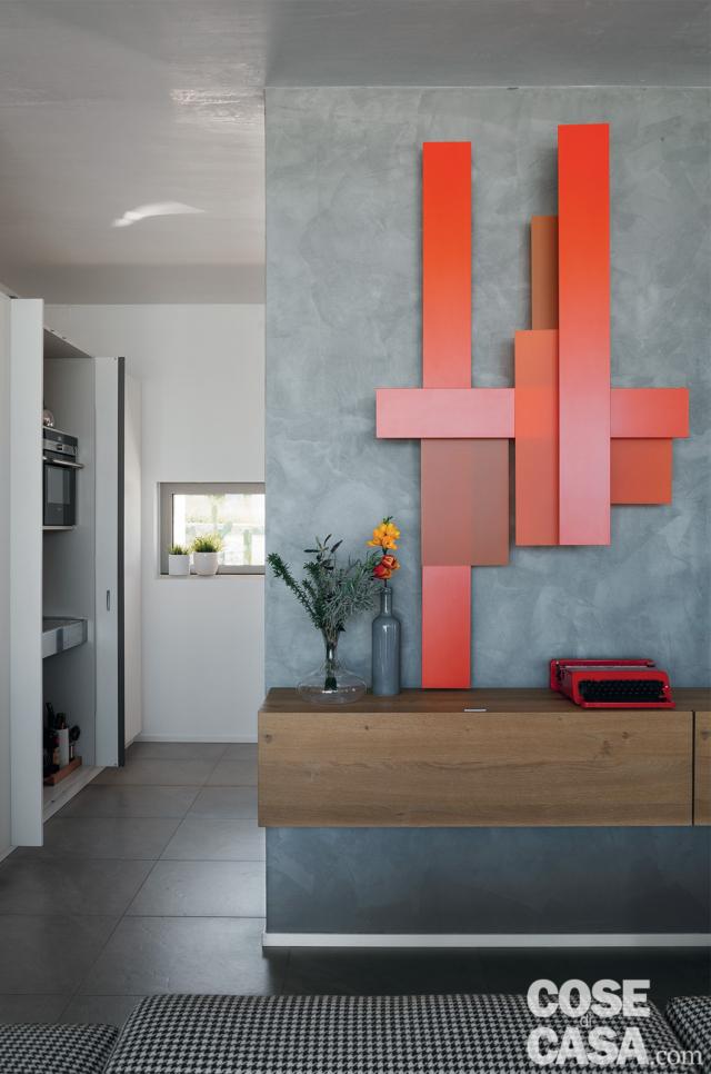 soggiorno, mobile in legno sospeso, lampada modulare rossa, parete rifinita effetto cemento, tappeto, libreria bianca soggiorno, mobile in legno sospeso, lampada modulare rossa, parete rifinita effetto cemento, tappeto, libreria bianca