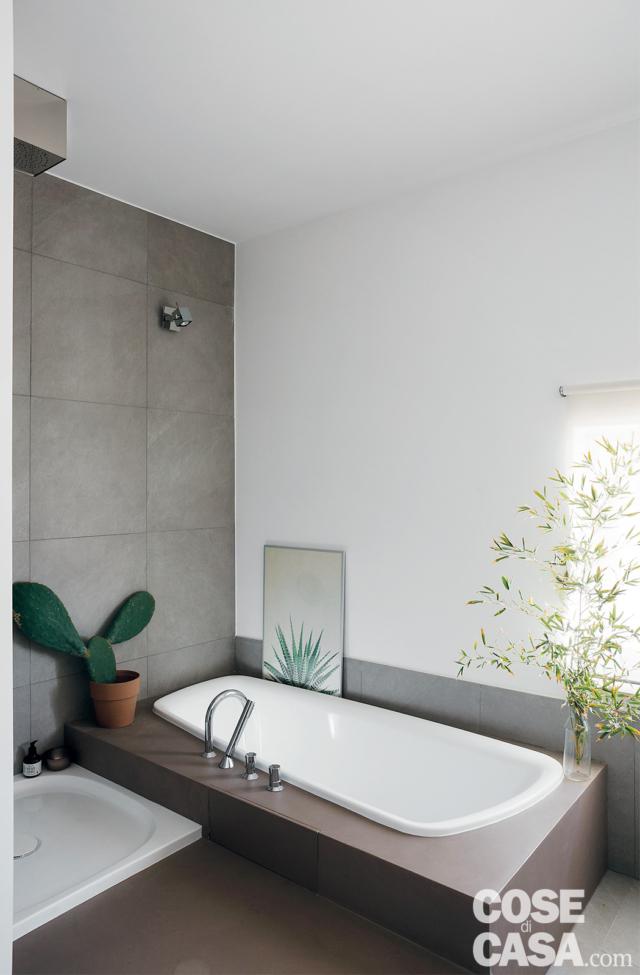 bagno, rivestimento in gres grigio a parete, pedana, vasca incassata, piatto doccia a una quota inferiore, finestra bagno, rivestimento in gres grigio a parete, pedana, vasca incassata, piatto doccia a una quota inferiore, finestra