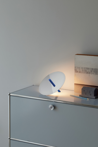 Millimetro (design Daniel Rybakken) di Luceplan ha un sottile disco specchiato sostenuto da uno stelo che funziona da sensore di comando per accensione, spegnimento e regolazione di intensità luminosa (H 17cm, L 18 x H 17 x P 23,5 cm). La sorgente luminosa è contenuta nell'ottica piatta fissata sulla superficie posteriore del disco. Costa 295,00 euro.