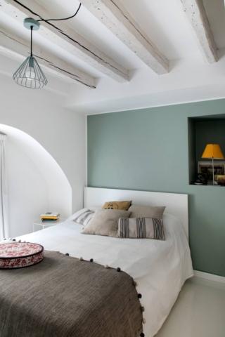 Camera da letto con letto bianco e parete colorata per farlo risaltare Camera da letto con letto bianco e parete colorata per farlo risaltare