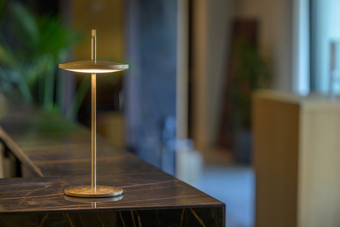 Thaïs (design Marcello Ziliani, foto Ottavio Tomasini) di Platek ha un disco luminoso attraversato da una sottile asta verticale (H 38 cm), lungo cui regolarne l'altezza o rimuoverlo, per usarlo sospeso a un cavo o direttamente posato su un piano, grazie ad un accessorio ad hoc. www.platek.eu