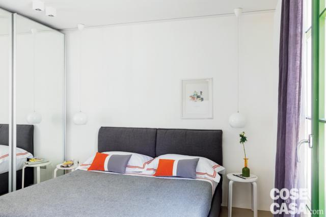 camera matrimoniale della mini casa, letto, testiera imbottita rivestita in tessuto viola, tavolini bianchi, cuscini, tendaggio viola, armadio con anta scorrevole specchiata camera matrimoniale della mini casa, letto, testiera imbottita rivestita in tessuto viola, tavolini bianchi, cuscini, tendaggio viola, armadio con anta scorrevole specchiata