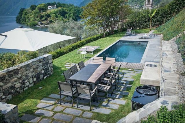 giardino della mini casa, vista dall'alto, zona pranzo, piscina, solarium, prato, rivestimenti in pietra, ombrellone, siepi, alberi, vista lago giardino della mini casa, vista dall'alto, zona pranzo, piscina, solarium, prato, rivestimenti in pietra, ombrellone, siepi, alberi, vista lago