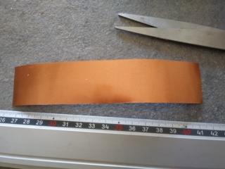 Ritagliate un rettangolo alto 3 cm nella lamina di metallo, per ricoprire tutto il rotolino. Ritagliate un rettangolo alto 3 cm nella lamina di metallo, per ricoprire tutto il rotolino.