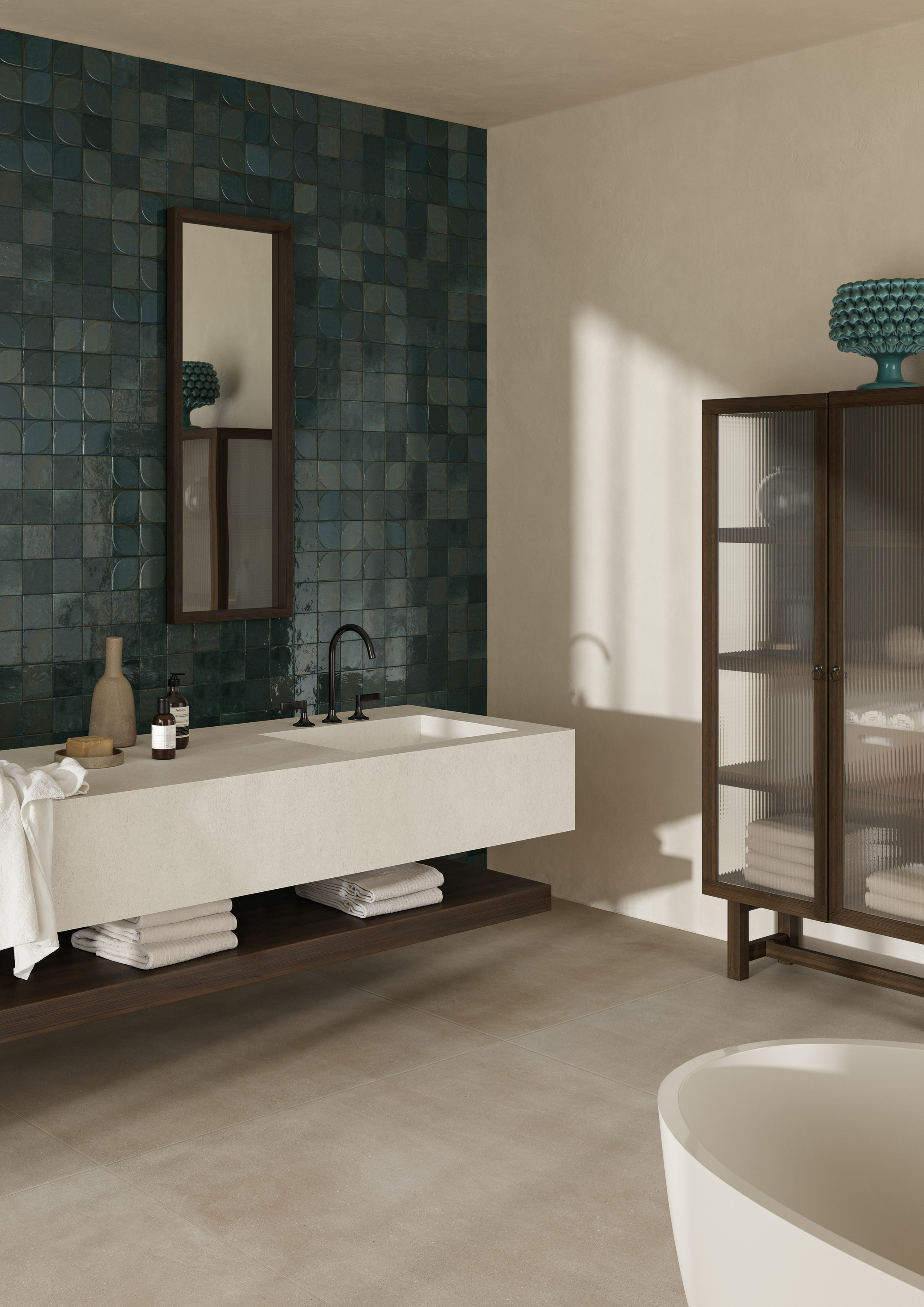 Il rivestimento del bagno, nel formato 10x10cm, con il decoro 3D Dew, una foglia in rilievo che introduce un movimento luminoso e scenografico nelle superfici, è della collezione Crogiolo Lume di Marazzi. Otto le tonalità della palette – ispirate ai cromatismi della natura, tra blu profondi, verdi intensi e caldi riflessi caramello – prendono vita su superfici lucide, ricche di profondità e vibranti di luce. Le leggere imperfezioni degli smalti e la brillantezza materica trasformano il gres in una sostanza viva, capace di evocare l’arte delle maioliche fatte a mano e restituire un’estetica autentica, densa di espressività. www.marazzi.it