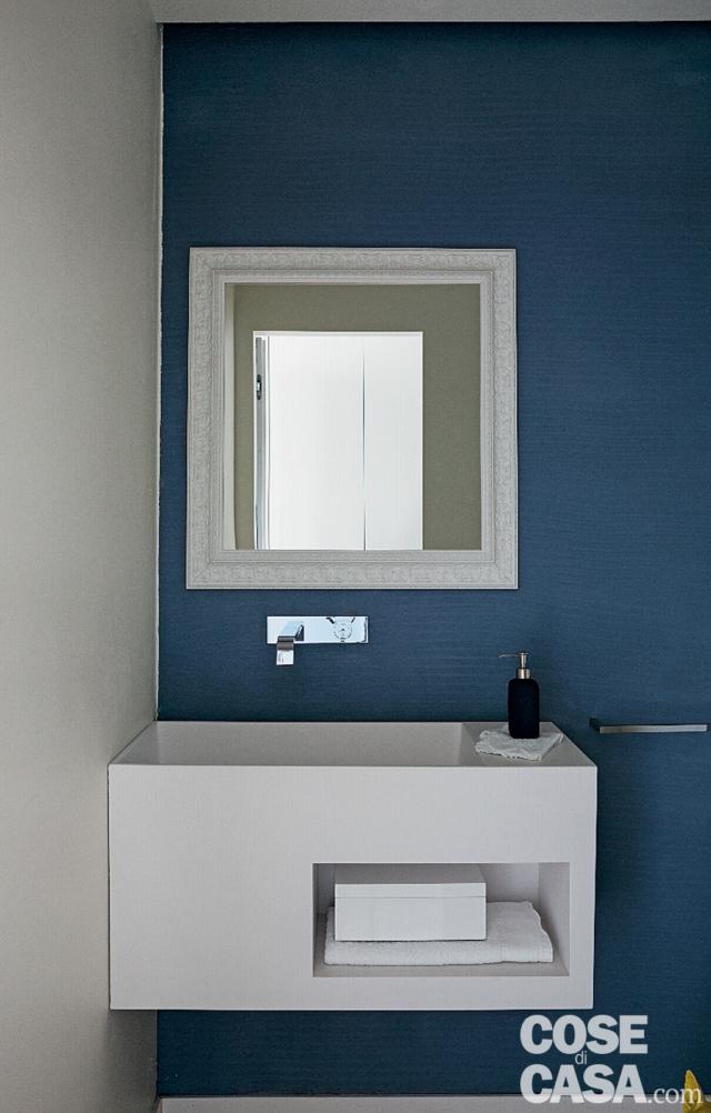 bagno degli ospiti, parete blu, specchio con cornice bianca, mobile sospeso con lavabo integrato, rubinetto a placca bagno degli ospiti, parete blu, specchio con cornice bianca, mobile sospeso con lavabo integrato, rubinetto a placca