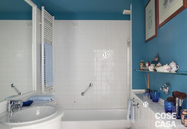 bagno, vasca, piastrelle bianche lucide a parete, lavabo ovale, specchio, controparete, pareti blu avio, mensola, stampe incorniciate, scaldasalviette bianco bagno, vasca, piastrelle bianche lucide a parete, lavabo ovale, specchio, controparete, pareti blu avio, mensola, stampe incorniciate, scaldasalviette bianco
