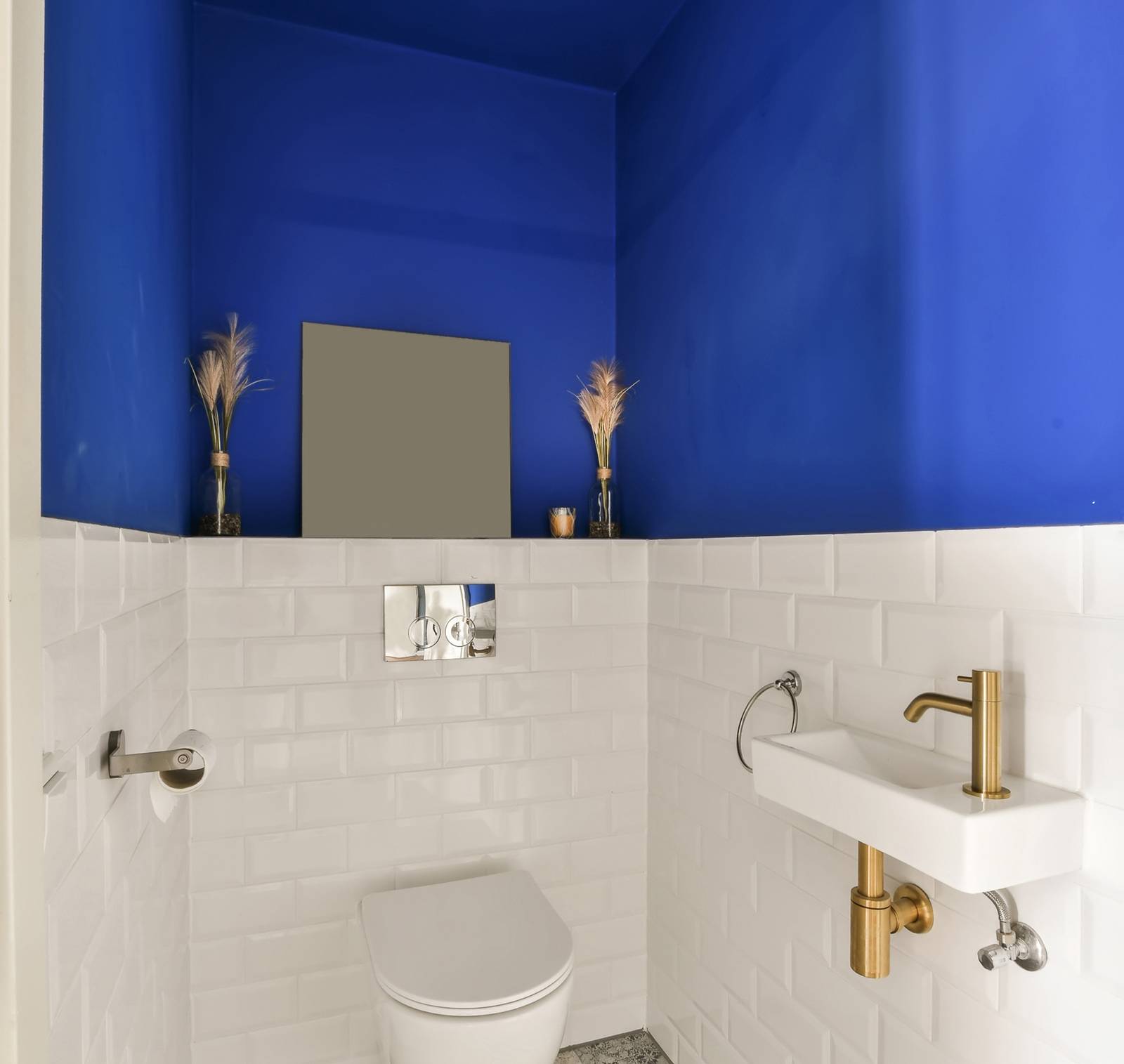 a blue and white bathroom with a toilet and sink
