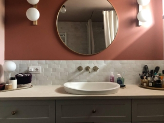 Il bagno etnico con piastrelle bianche mosse nella sola fascia bassa dietro il mobile Il bagno etnico con piastrelle bianche mosse nella sola fascia bassa dietro il mobile