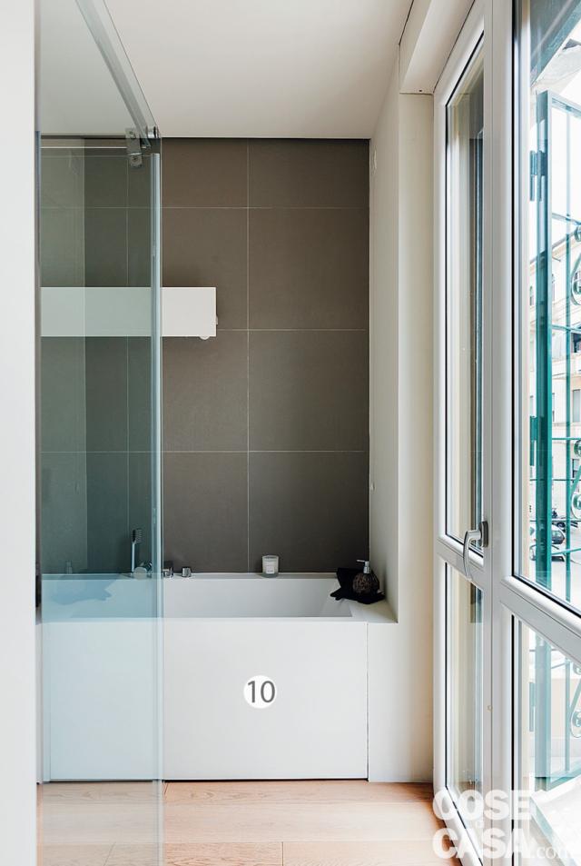 bagno, parete rivestita in gres grigio, box doccia trasparente, vasca in acrilico, portafinestra con inferriate bagno, parete rivestita in gres grigio, box doccia trasparente, vasca in acrilico, portafinestra con inferriate
