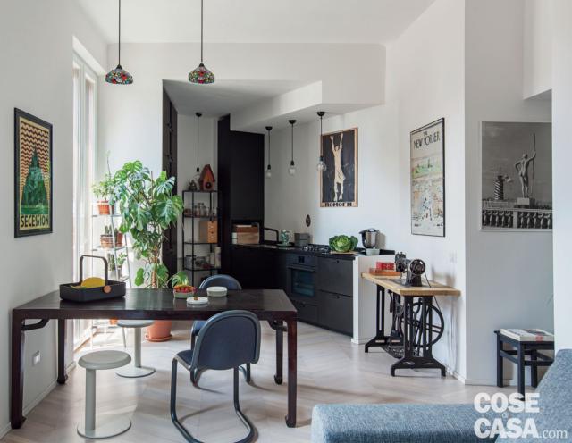 zona pranzo del bilocale di 60 mq, zona pranzo, tavolo rettangolare nero, sedie, sgabelli bianchi, zona cottura in finitura scura, lampade a sospensione zona pranzo del bilocale di 60 mq, zona pranzo, tavolo rettangolare nero, sedie, sgabelli bianchi, zona cottura in finitura scura, lampade a sospensione