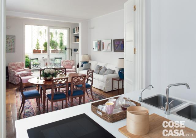 soggiorno del trilocale ristrutturato, tavolo da pranzo ovale in legno, sedie coordinate, divano bianco, cuscini, vetrata, terrazzo, pavimento in piastrelle, porta a libro, isola della cucina, lavello a due vasche, piano cottura a induzione soggiorno del trilocale ristrutturato, tavolo da pranzo ovale in legno, sedie coordinate, divano bianco, cuscini, vetrata, terrazzo, pavimento in piastrelle, porta a libro, isola della cucina, lavello a due vasche, piano cottura a induzione