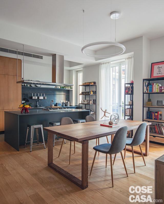 zona pranzo, tavolo in legno, sedie, parquet in rovere, lampada a sospensione circolare, librerie a giorno, portafinestra, isola della cucina, cappa sospesa zona pranzo, tavolo in legno, sedie, parquet in rovere, lampada a sospensione circolare, librerie a giorno, portafinestra, isola della cucina, cappa sospesa
