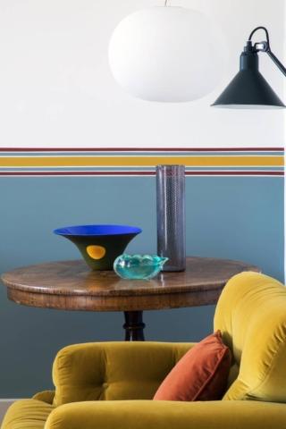 Zona giorno con un vecchio tavolo e una vecchia poltrona abbinati a luci moderne Zona giorno con un vecchio tavolo e una vecchia poltrona abbinati a luci moderne