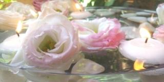 Centrotavola con fiori sassi e candele galleggianti