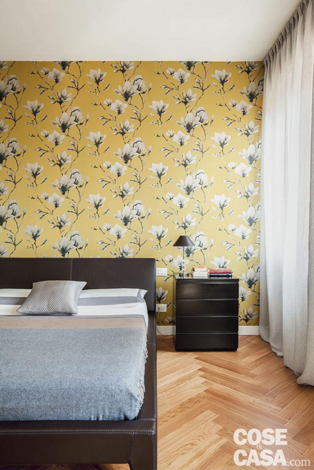 camera matrimoniale, parete rivestita in carta da parati gialla décor, letto rivestito in pelle, portafinestra, parquet a spina di pesce, comodino nero, tendaggi camera matrimoniale, parete rivestita in carta da parati gialla décor, letto rivestito in pelle, portafinestra, parquet a spina di pesce, comodino nero, tendaggi