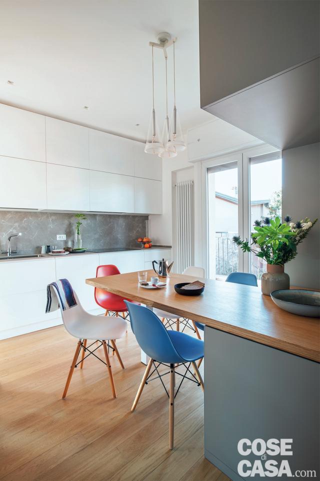 cucina, composizione a parete in laccato bianco, alzata grigia, portafinestra, bancone a penisola, sedie di design colorate, lampade a sospensione, pavimento in parquet di rovere cucina, composizione a parete in laccato bianco, alzata grigia, portafinestra, bancone a penisola, sedie di design colorate, lampade a sospensione, pavimento in parquet di rovere