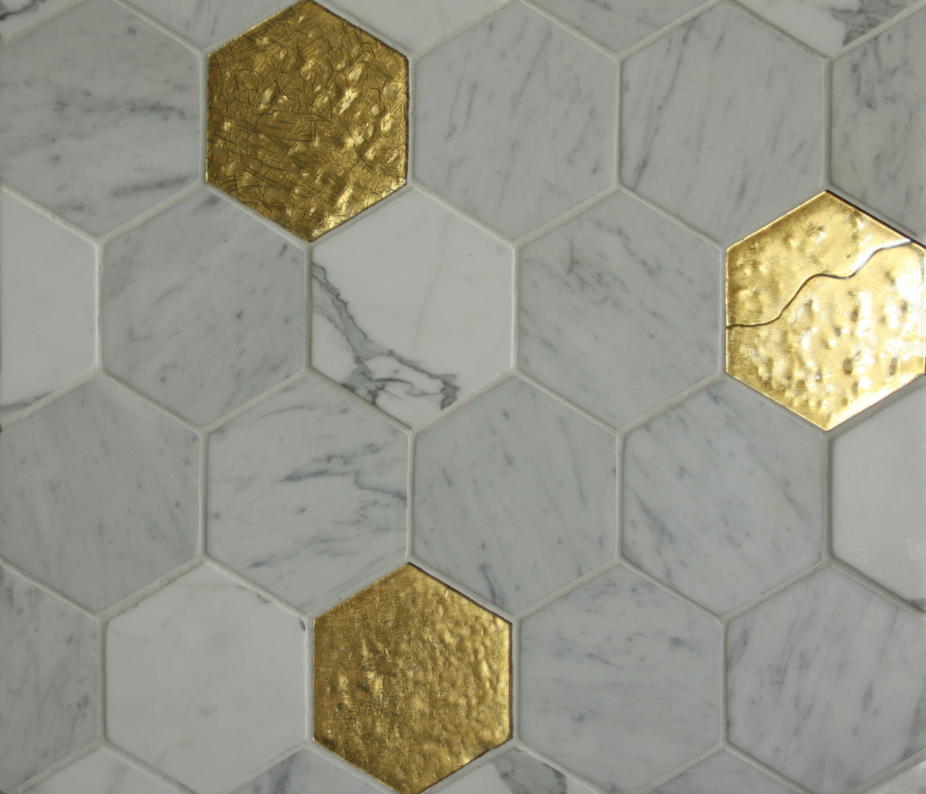 La collezione Hexagoni di Mya Design abbina in modo inedito ed elegante il marmo bianco di Carrara anticato e trattato e il vetro di Murano Oro Craquelé per un rivestimento dall’espressività importante. La geometria primaria dell’esagono, declinata sia nella naturalità della pietra naturale sia nella preziosità del vetro dorato, dona all’insieme un effetto senza tempo e insieme estremamente contemporaneo. www.myadesign.it La collezione Hexagoni di Mya Design abbina in modo inedito ed elegante il marmo bianco di Carrara anticato e trattato e il vetro di Murano Oro Craquelé per un rivestimento dall’espressività importante. La geometria primaria dell’esagono, declinata sia nella naturalità della pietra naturale sia nella preziosità del vetro dorato, dona all’insieme un effetto senza tempo e insieme estremamente contemporaneo. www.myadesign.it