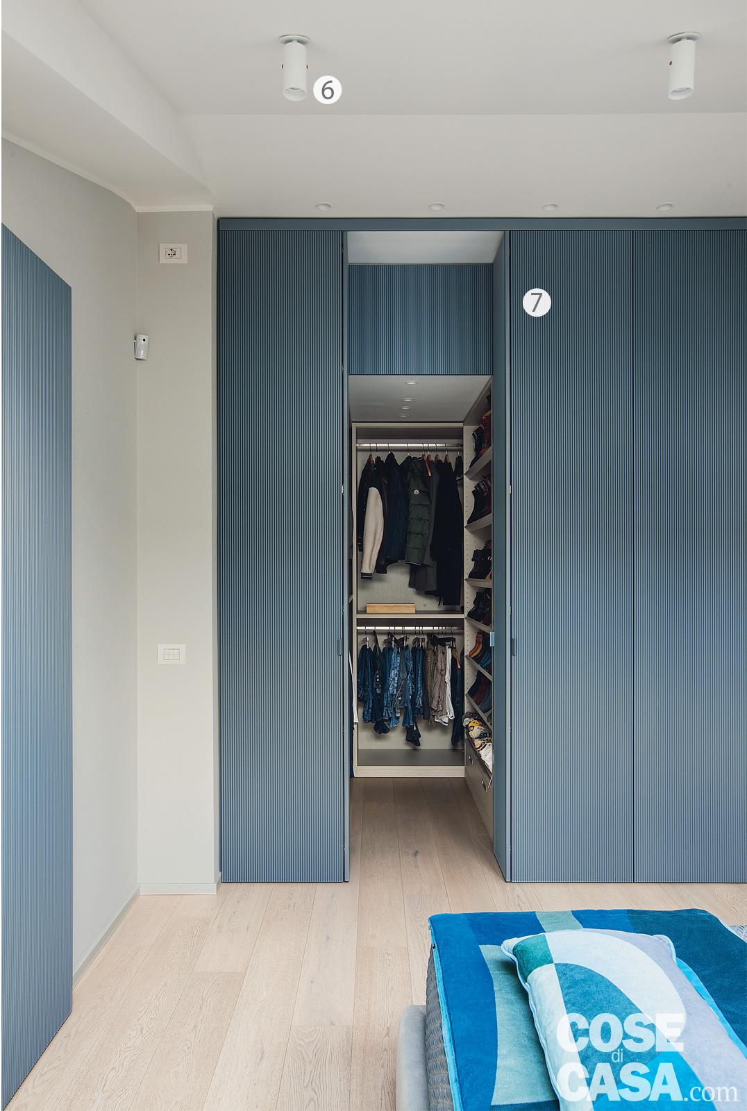 Nella zona notte la stanza matrimoniale è organizzata come una suite, completata dalla cabina armadio e dal bagno a uso esclusivo. La tonalità sofisticata di grigio-blu che uniforma tutta l'abitazione è ripresa anche in quest'ambiente, sia per le soluzioni su disegno del progettista che per le finiture personalizzate, come nel caso delle pannellature fresate con lavorazioni artigianali. Le pannellature della cabina armadio sono state realizzate su disegno del progettista. Nella zona notte la stanza matrimoniale è organizzata come una suite, completata dalla cabina armadio e dal bagno a uso esclusivo. La tonalità sofisticata di grigio-blu che uniforma tutta l'abitazione è ripresa anche in quest'ambiente, sia per le soluzioni su disegno del progettista che per le finiture personalizzate, come nel caso delle pannellature fresate con lavorazioni artigianali. Le pannellature della cabina armadio sono state realizzate su disegno del progettista.