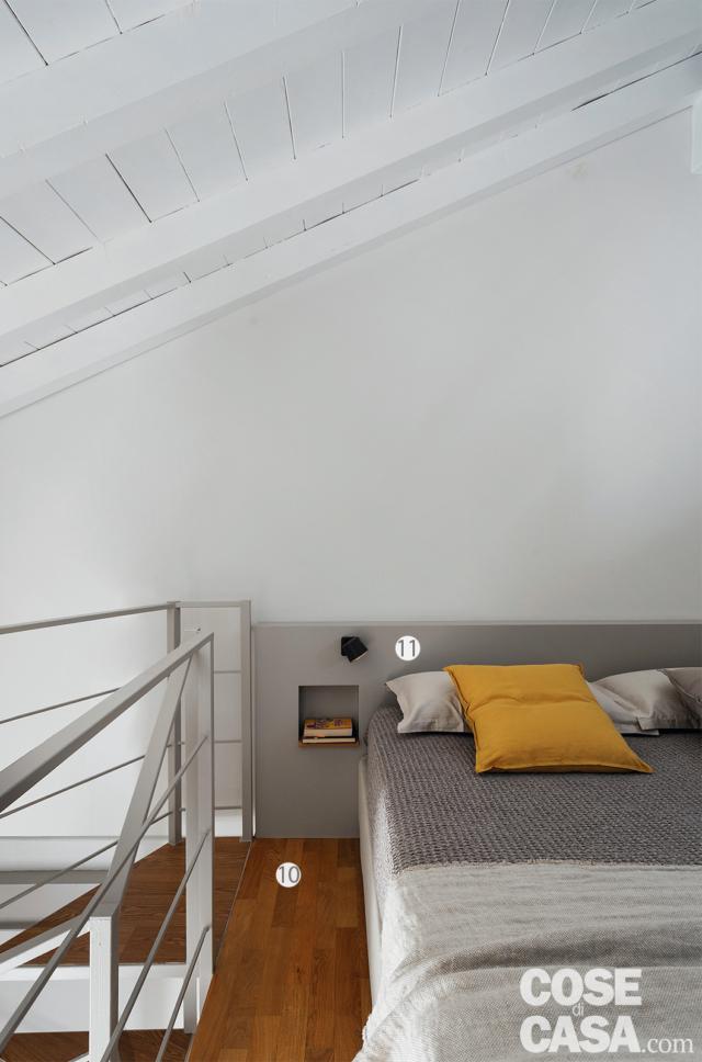 sottotetto, scala, letto matrimoniale, cuscino giallo, boiserie con comodini, tetto a falda in legno verniciato bianco, pavimento in parquet sottotetto, scala, letto matrimoniale, cuscino giallo, boiserie con comodini, tetto a falda in legno verniciato bianco, pavimento in parquet