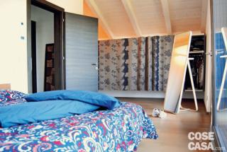 sottotetto con camera matrimoniale in casa prefabbricata; armadio in tessuto e soffitto legno a vista sottotetto con camera matrimoniale in casa prefabbricata; armadio in tessuto e soffitto legno a vista