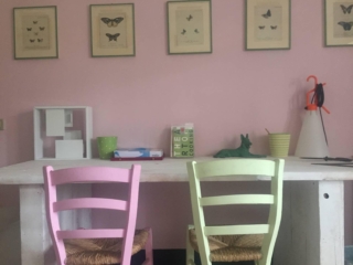 Camera con scrivania chiara e sedie in legno colori baby pastello