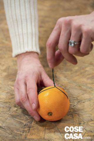 3. Arrotolare bene i due capi ottenendone uno solo stabile. Ferrare in questo modo tutte le arance. 3. Arrotolare bene i due capi ottenendone uno solo stabile. Ferrare in questo modo tutte le arance.