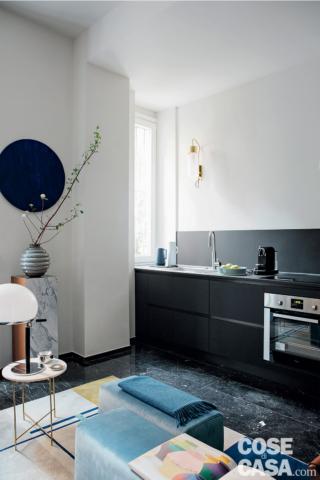 cucina, composizione in linea senza pensili in finitura nera, finestra, forno, lavello, pavimento in marmo, tavolino con piano in vetro, tavolino rotondo, piedistallo, vaso a righe cucina, composizione in linea senza pensili in finitura nera, finestra, forno, lavello, pavimento in marmo, tavolino con piano in vetro, tavolino rotondo, piedistallo, vaso a righe