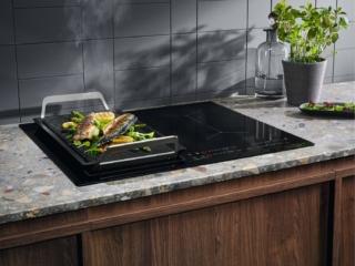 Attraverso il sensore presente nelle 4 zone cottura Infinite, il piano a induzione SenseBoil® EIS62449C di Electrolux percepisce le vibrazioni della bollitura dell’acqua e regola in maniera automatica il livello di calore. Caratterizzato da un’estetica nera, ha anche funzione PowerSlide che al tocco di un comando sul display digitale attiva tre livelli di temperatura preimpostati (alta, media, bassa) così da far scorrere con facilità la padella dalla zona più calda a quella più fredda senza la necessità di gestire manualmente la potenza. Da 60 cm, è regolabile fino a 14 livelli e può essere collegato wireless alla cappa. Prezzo 830 euro. www.electrolux.it