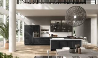 Il modello Ylenia di Aran Cucine si apre completamente sul living. Le ante riquadrate delle basi e delle colonne sono in frassino laccato a poro aperto nero opaco che crea un raffinato effetto optical con il piano di lavoro in grès statuario soft bianco. L'isola si collega alla parte attrezzata per mezzo di un pratico bancone snack nella finitura legno scuro. I pensili hanno il telaio in alluminio e vetro fumé. Un modulo base da 60 cm, prezzo a partire da 235 euro. www.arancucine.it