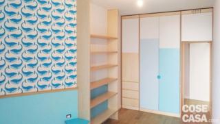 Nella cameretta, il lato corto della parete alla quale è appoggiata la testiera del letto è parzialmente rivestita da una tappezzeria di Carte da parati degli anni '70. Il letto con seconda rete estraibile, il copriletto, il plaid e i cuscini sono di Ikea. Nella fascia bassa, la boiserie è rivestita in laminato azzurro e il comodino, in una tonalità leggermente più satura, è sagomato. Nella cameretta, il lato corto della parete alla quale è appoggiata la testiera del letto è parzialmente rivestita da una tappezzeria di Carte da parati degli anni '70. Il letto con seconda rete estraibile, il copriletto, il plaid e i cuscini sono di Ikea. Nella fascia bassa, la boiserie è rivestita in laminato azzurro e il comodino, in una tonalità leggermente più satura, è sagomato.