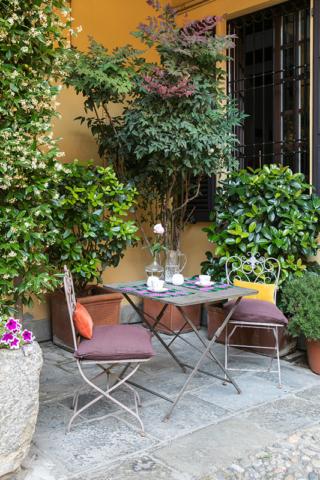 Cortiletto provenzale con mobili pieghevoli
Dedicato a chi abita al piano terra in un cortile: in questo caso lo spazio esterno spesso diventa il luogo dove parcheggiare bici e moto, ma quando la giornata è bella o durante il weekend questo spazio diventa l’angolo preferito per la colazione o un aperitivo tra il verde. E aver scelto mobili di sapore retrò lo rende più intimo e accogliente
L’idea: Il tavolino in ferro con le due sedie arrivano da un mercatino provenzale, ed essendo pieghevoli sono facilmente richiudibili: in un attimo spariscono dietro la porta, pronte all’uso!  Un’idea nata durante il lockdown e che continua da essere perfetta! Cortiletto provenzale con mobili pieghevoli
Dedicato a chi abita al piano terra in un cortile: in questo caso lo spazio esterno spesso diventa il luogo dove parcheggiare bici e moto, ma quando la giornata è bella o durante il weekend questo spazio diventa l’angolo preferito per la colazione o un aperitivo tra il verde. E aver scelto mobili di sapore retrò lo rende più intimo e accogliente
L’idea: Il tavolino in ferro con le due sedie arrivano da un mercatino provenzale, ed essendo pieghevoli sono facilmente richiudibili: in un attimo spariscono dietro la porta, pronte all’uso!  Un’idea nata durante il lockdown e che continua da essere perfetta!
