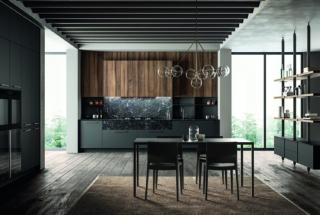 Kalì, composizione lineare con basi e colonne Pet maximatt opaco lavagna, maniglia 1180 finitura ottone, top e schienale Unicolor laminato pietra nera, cassetti h24cm pietra nera con apertura push pull; pensili e pannelli in laminato noce America.